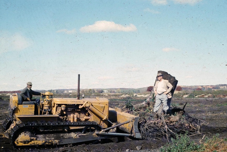 Ellis Huntsinger (pictured above on the right in 1956) tends to the fields with a fellow farmer.