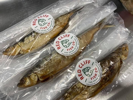 Fresh-caught, smoked lake herring is placed in environmentally friendly packaging for sale. Justin Maki brings up a load of lake herring from Duffy's Dock. Photo courtesy of Red Cliff Band of Lake Superior Chippewa.